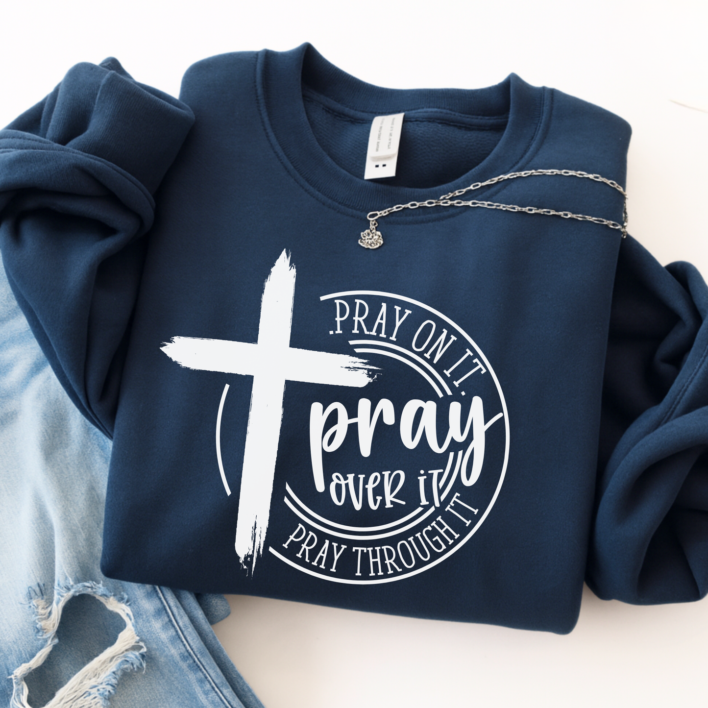 Navy blue sweatshirt with a cross and motivational text design on a light background