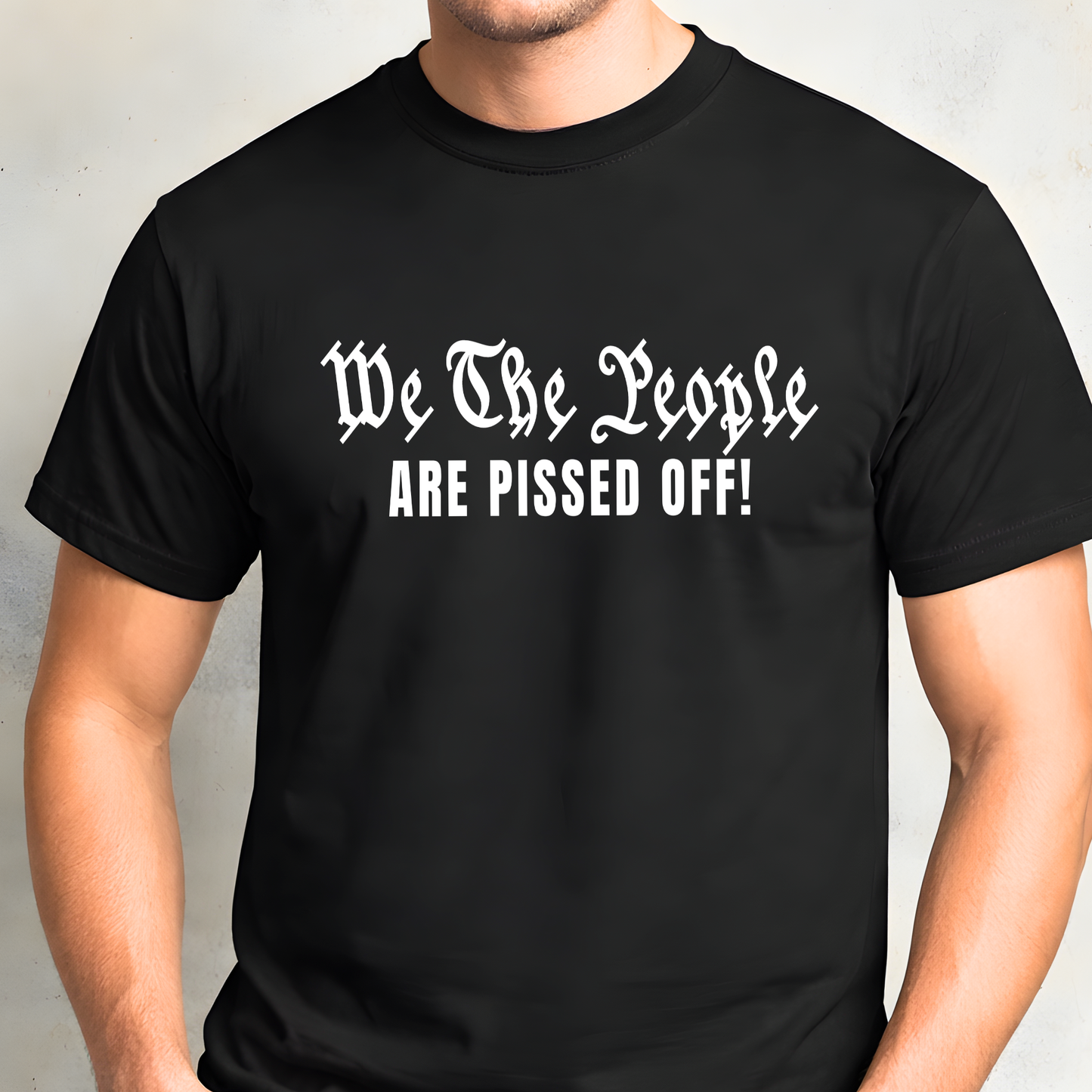 Black t-shirt with white text 'We The People ARE PISSED OFF!' worn by a man.