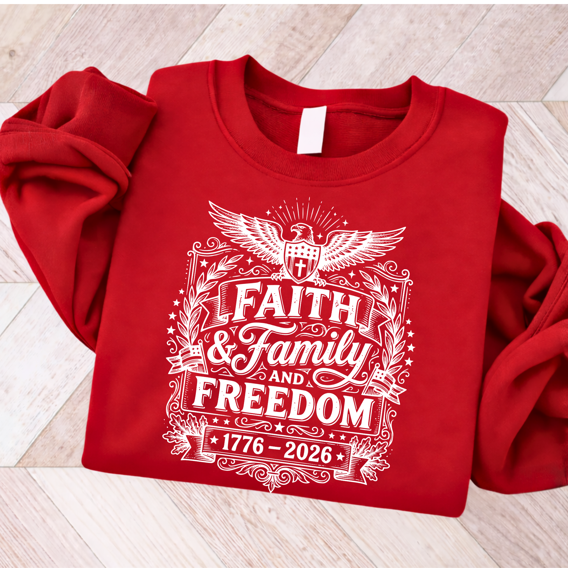 Red sweatshirt with white patriotic text and design on a wooden floor