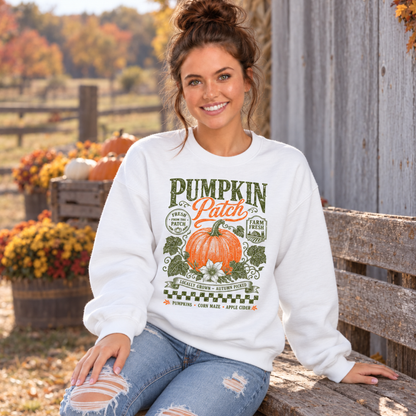 Woman wearing a white sweatshirt with vintage Pumpkin Patch pumpkin and floral design seated at a fall pumpkin farm