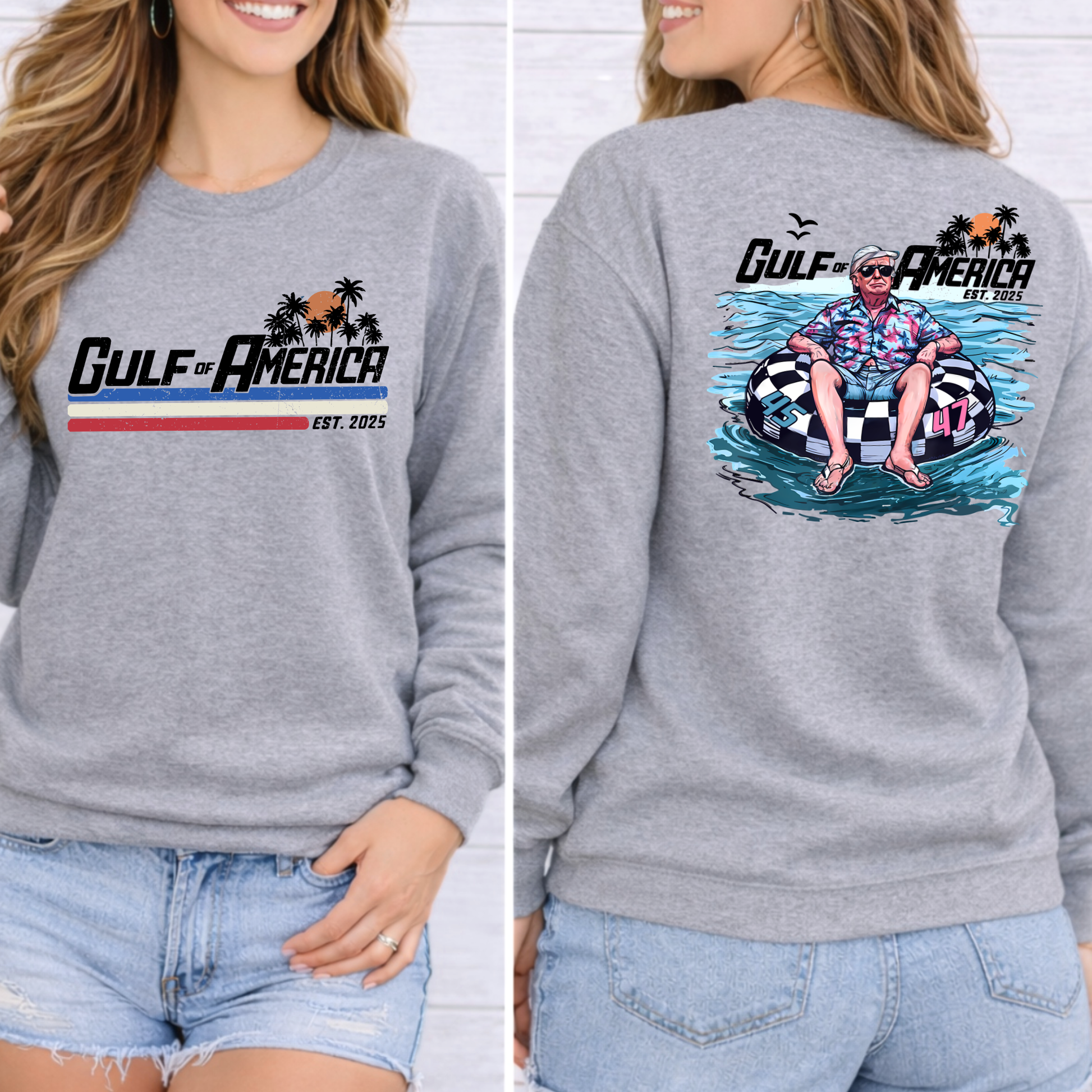 Gray sweatshirt with Donald Trump on a raft  and palm trees. 'Gulf of America' design on front and back, worn by a person.