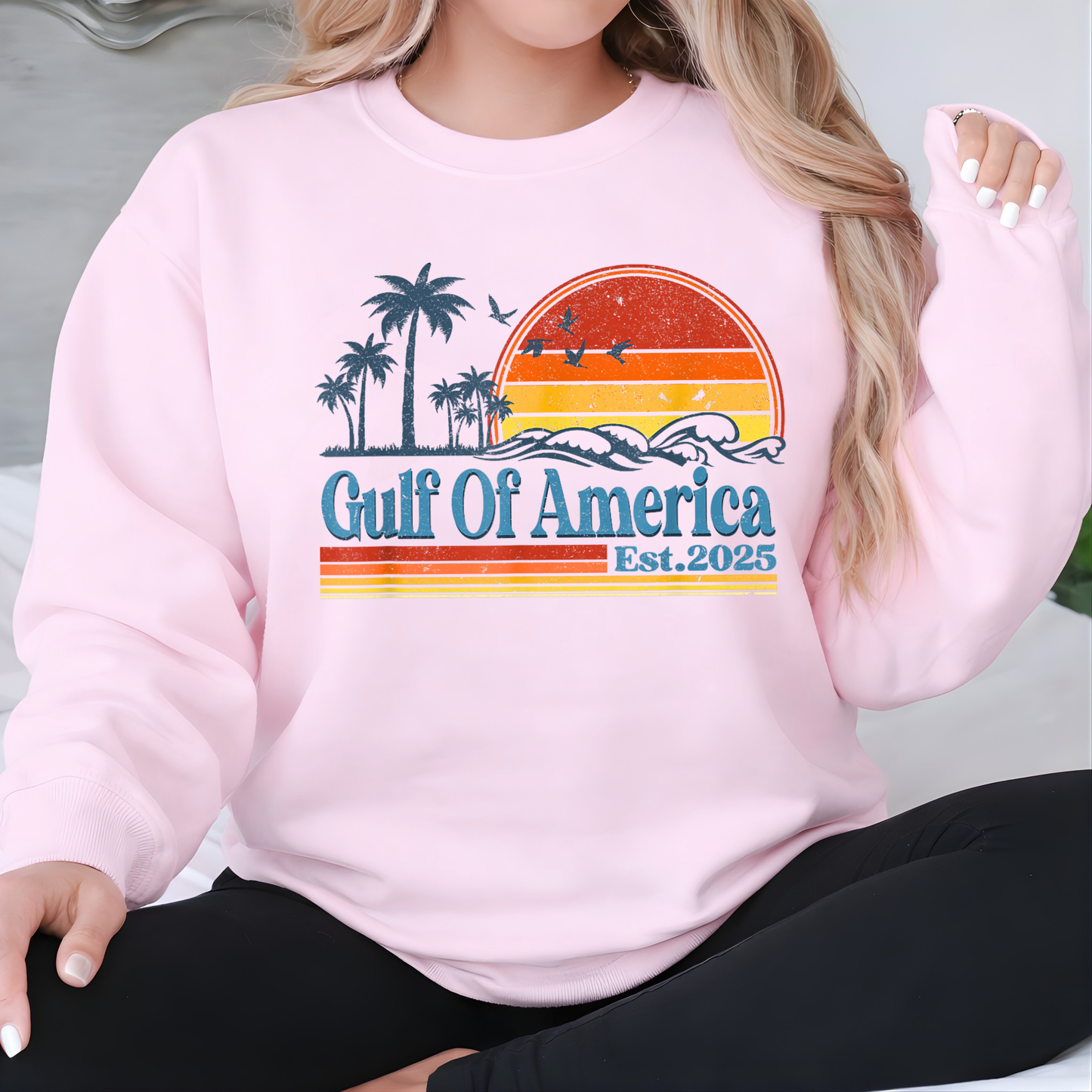 Woman wearing a pink sweatshirt with a 'Gulf of America' graphic design.