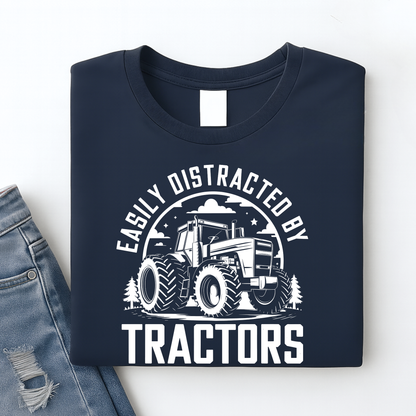 Navy blue t-shirt with tractor graphic and text 'Easily Distracted by Tractors' on a white background.