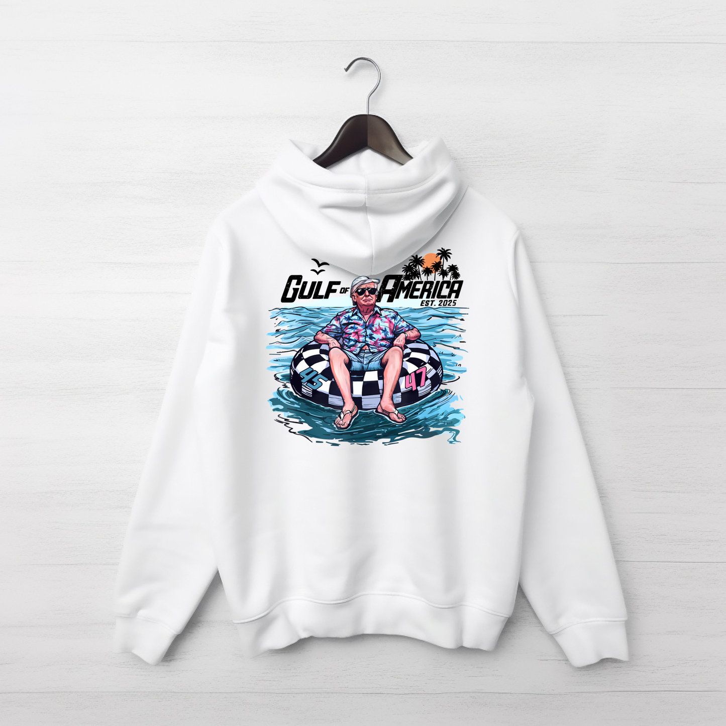 White hoodie with a graphic design of  Donald Trumpon an inner tube, hanging on a wooden hanger against a white background.