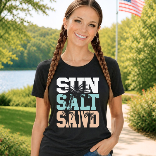 Woman wearing a black t-shirt with 'SUN SALT SAID' text and palm tree designat the lake