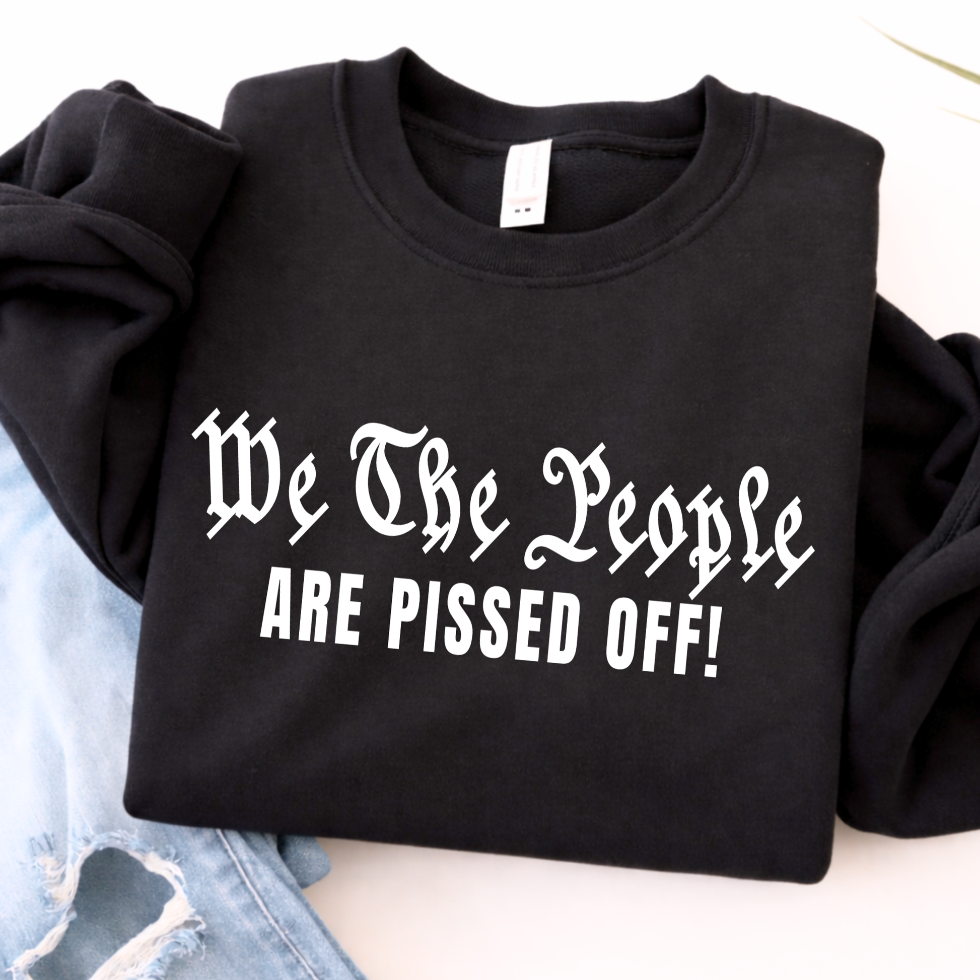 Black sweatshirt with text 'We The People ARE PISSED OFF!' on a light background