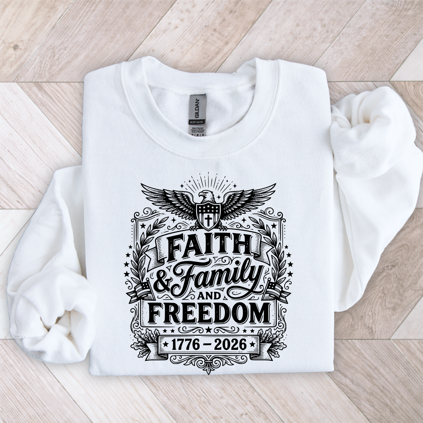 White sweatshirt with black patriotic graphic design on a wooden floor