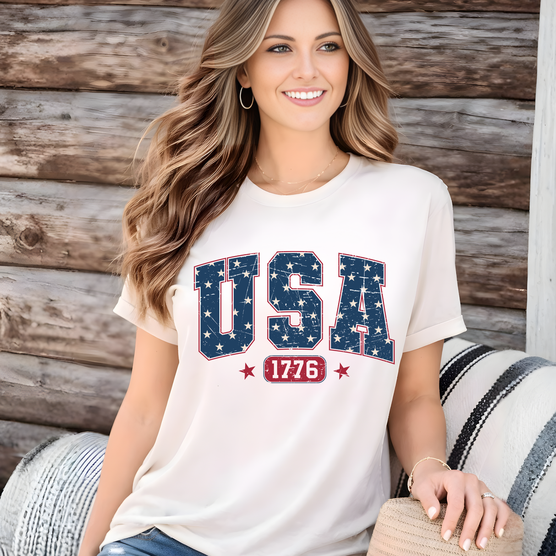 Woman wearing a America 250 USA 1776 patriotic t-shirt in sand beige, distressed American flag lettering, celebrating 250 years of freedom