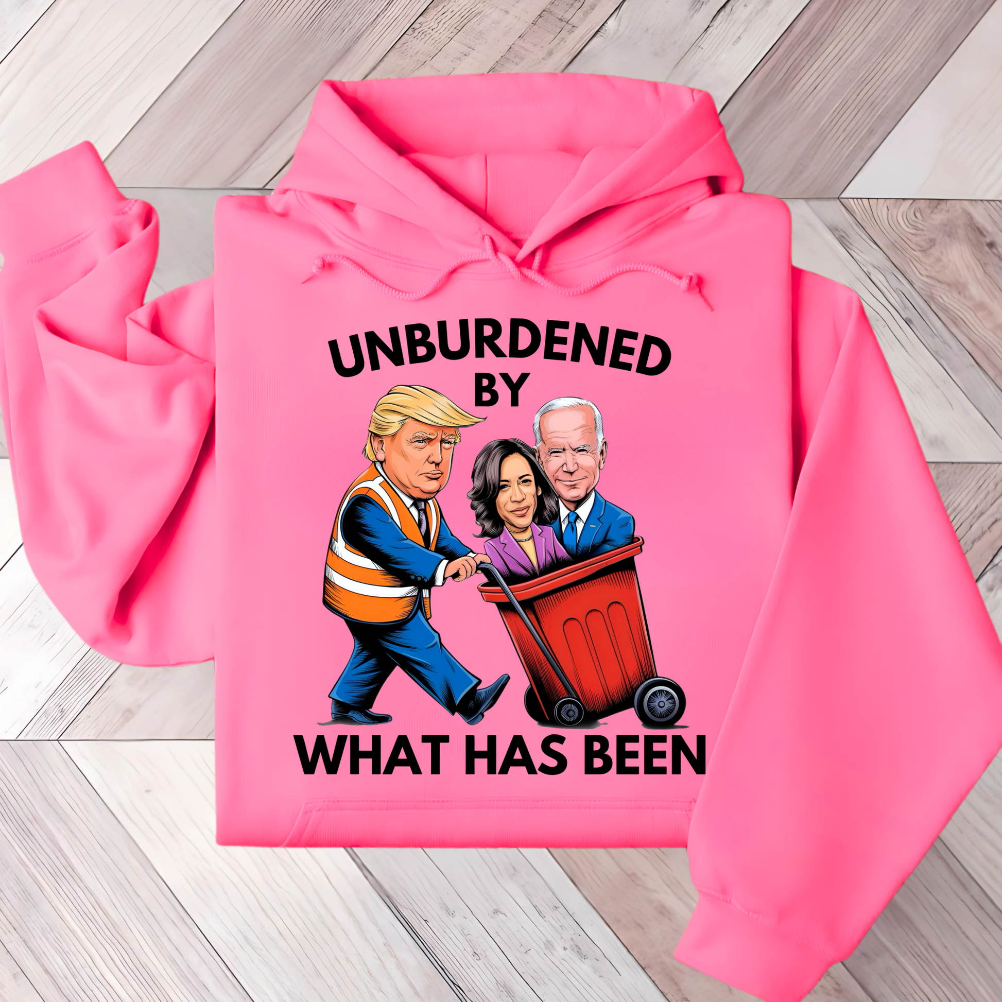 A woman wearing a white hoodie with a cartoon graphic of three political figures and the text 'UNBURDENED BY WHAT HAS BEEN'.