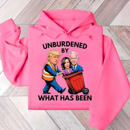A woman wearing a white hoodie with a cartoon graphic of three political figures and the text 'UNBURDENED BY WHAT HAS BEEN'.