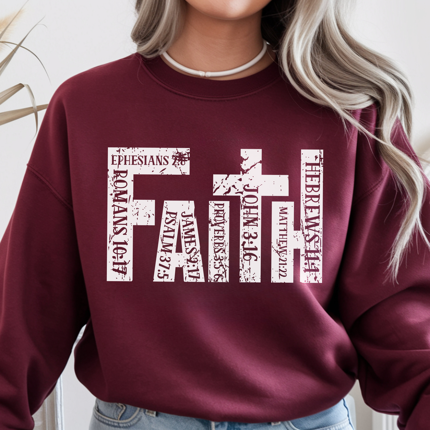 Maroon sweatshirt with 'FAITH' text design on a plain background