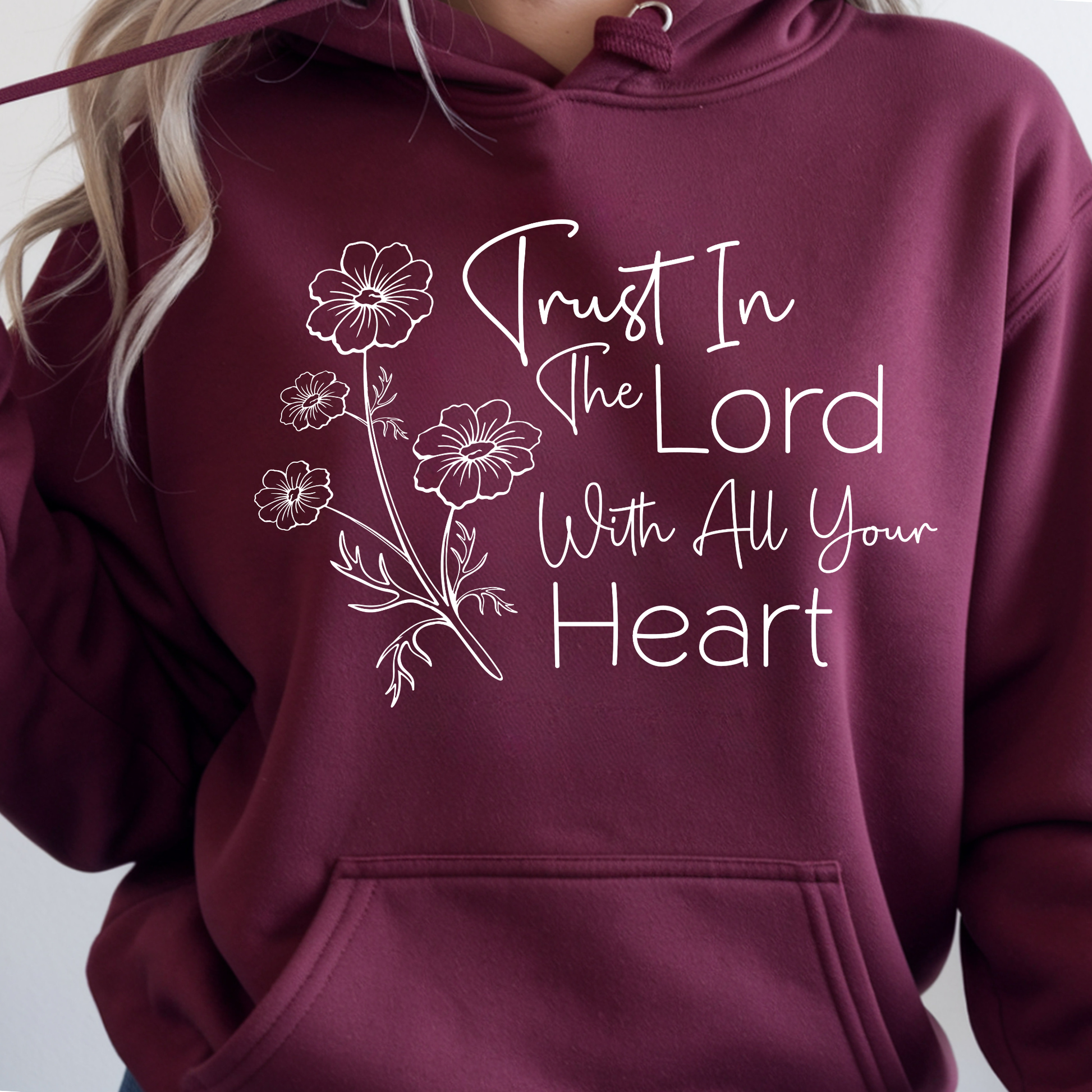 Maroon hoodie with floral design and text 'Trust In The Lord With All Your Heart' on a plain background