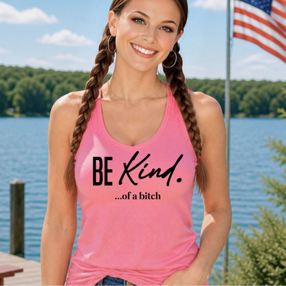 Woman wearing a pink tank top with 'BE KIND...of a bitch' text by a lake with an American flag in the background.