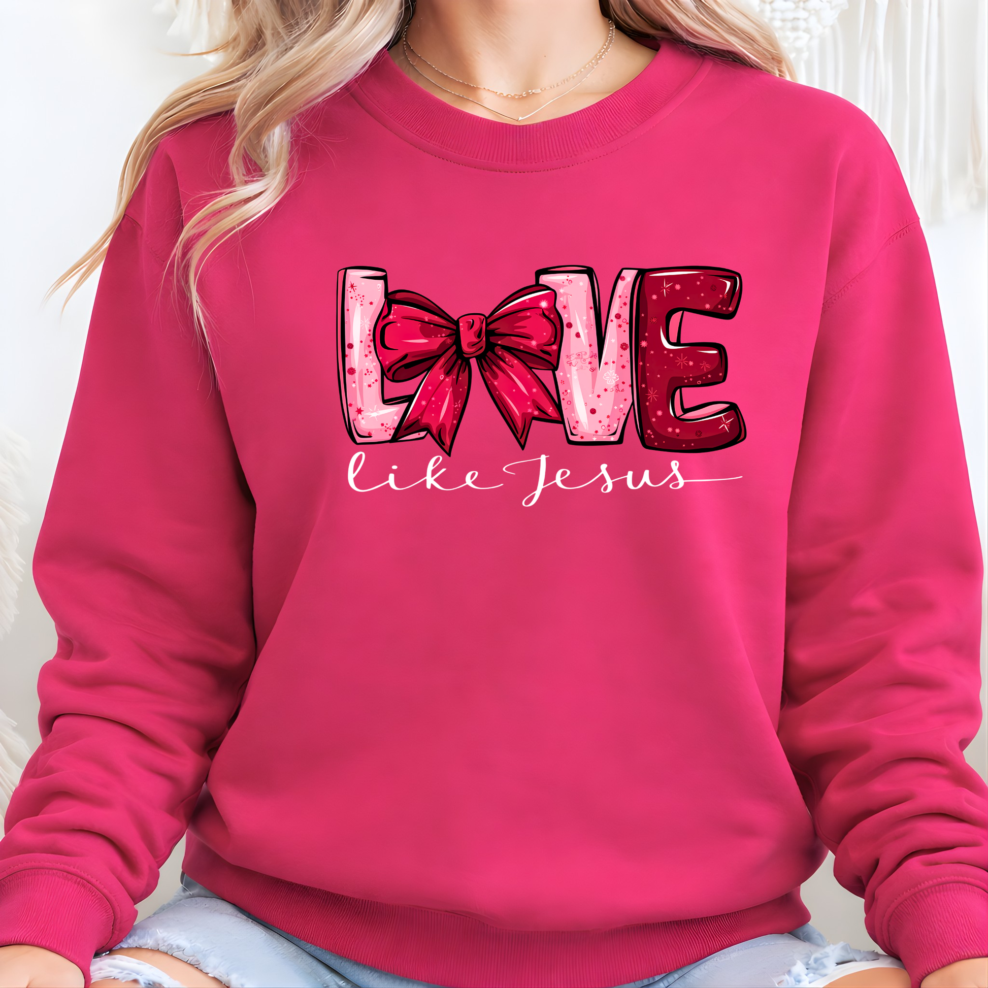 Pink sweatshirt with 'Love like Jesus' design featuring a bow and heart.