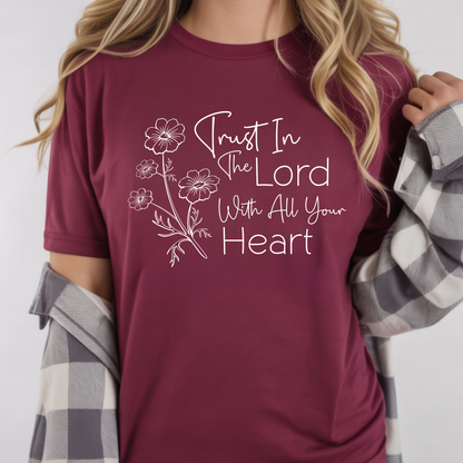 Maroon t-shirt with floral design and text 'Trust In The Lord With All Your Heart' worn by a woman.