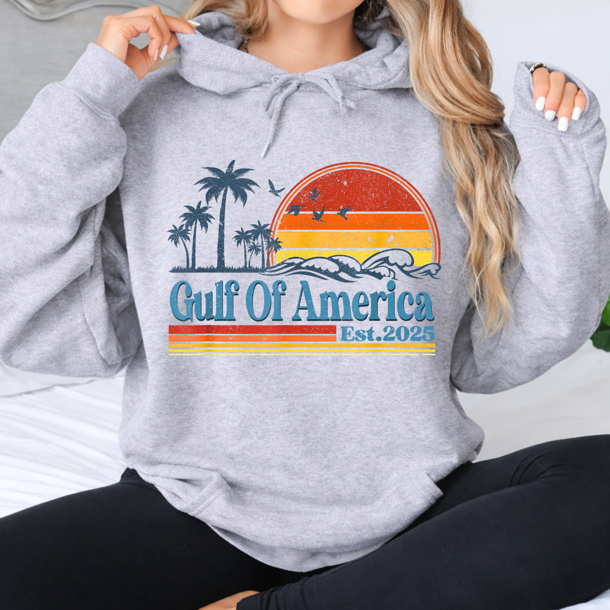 Woman wearing a gray hoodie with 'Gulf Of America' design