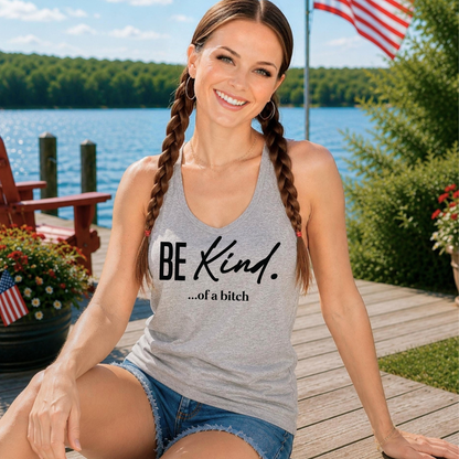 Woman wearing a tank top with 'BE Kind...of a bitch' text by a lake.