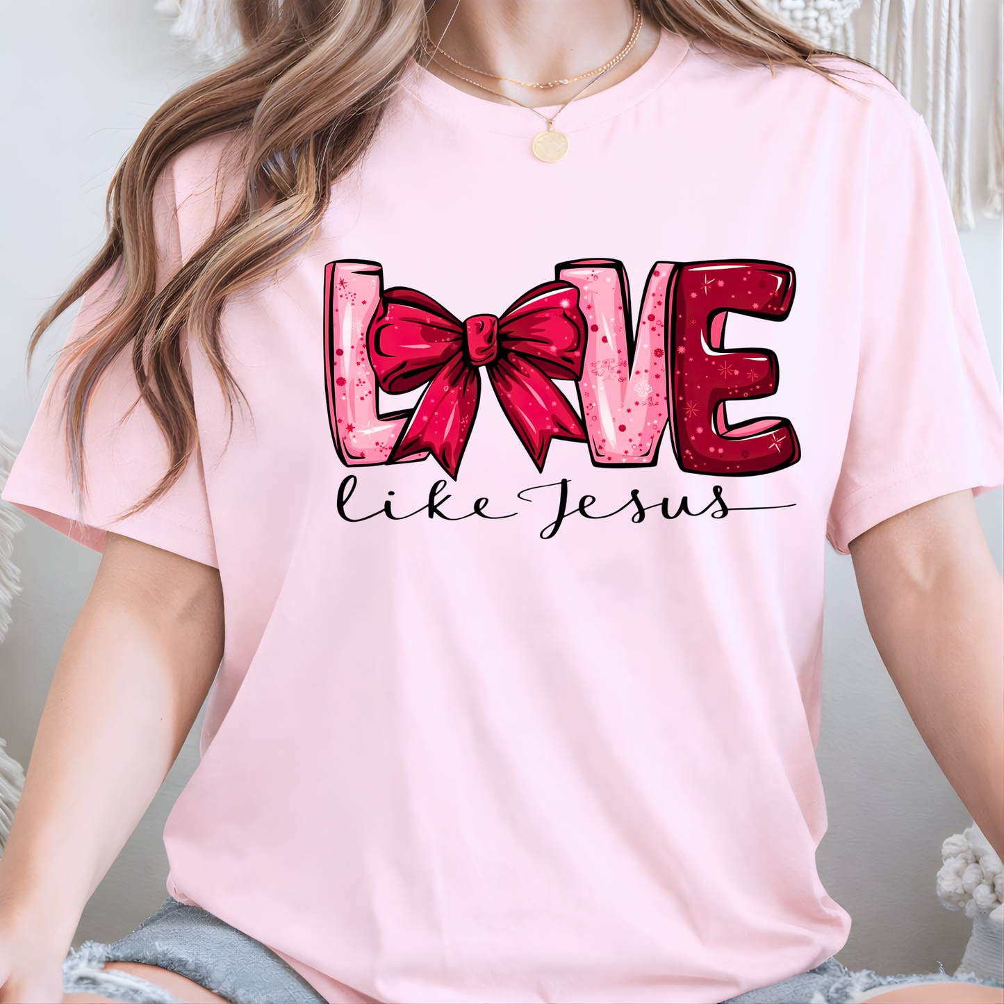 woman wearing a pink t-shirt with 'Love like Jesus' design