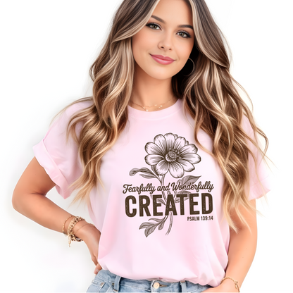 Woman wearing a pink t-shirt with a  Christian floral design and text on a white background