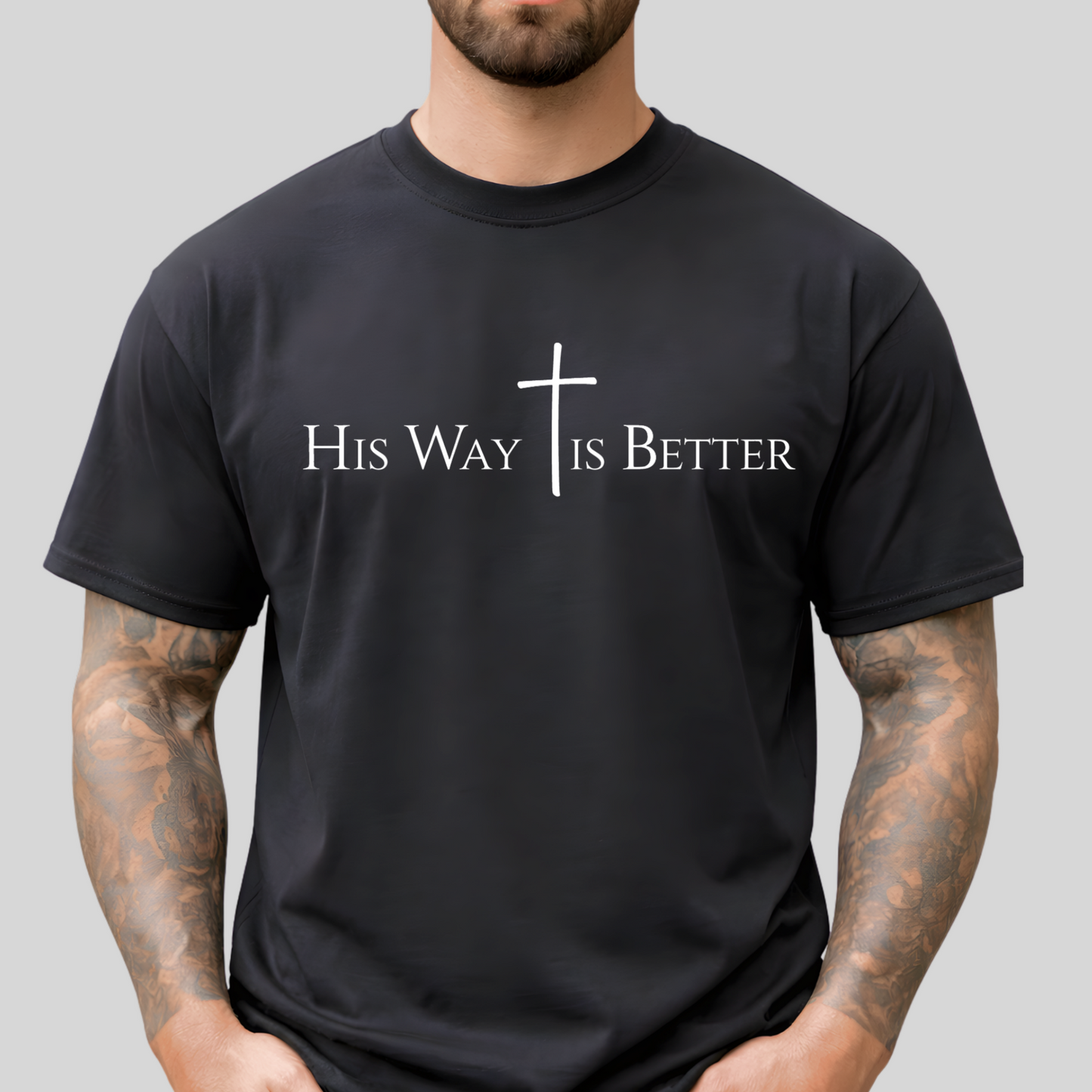 Person wearing a black t-shirt with 'His Way Is Better' text and cross design on a gray background