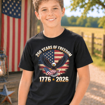 Child wearing a black America 250 years of Freedom t-shirt with an American flag and eagle design, standing outdoors with a flag in the background.