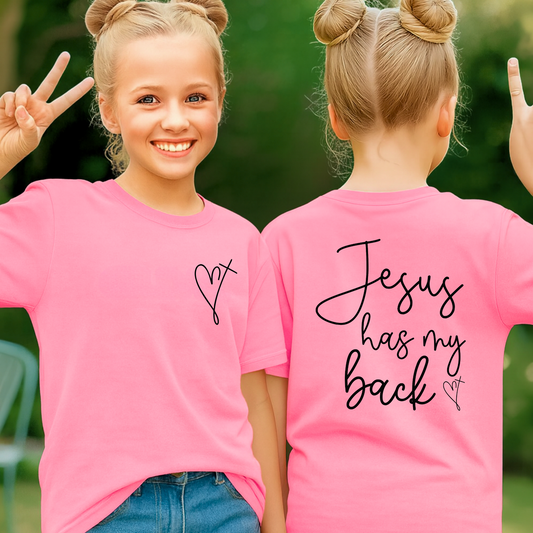 Two children wearing pink t-shirts with text, one facing the camera and the other showing 'Jesus has my back'.