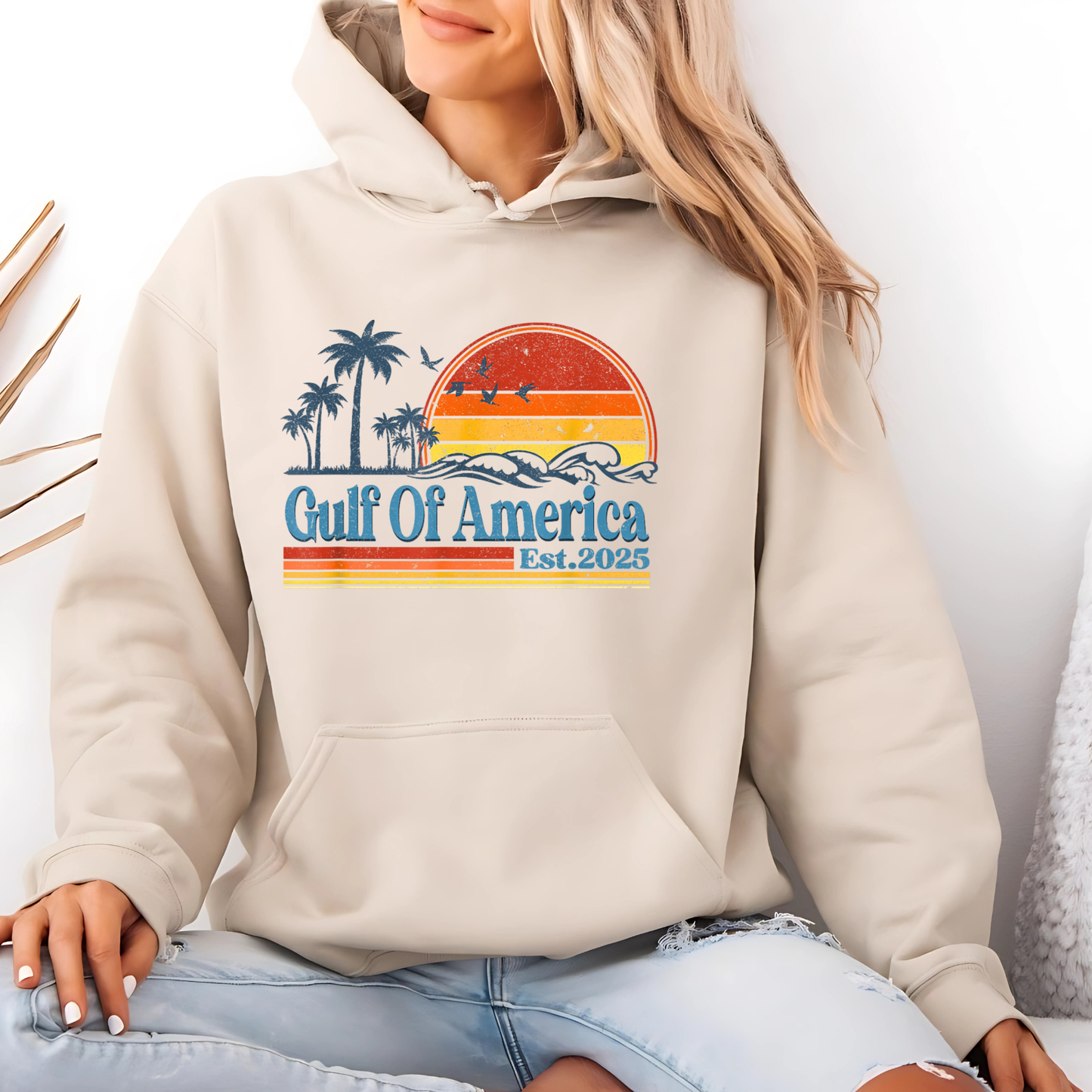 Beige hoodie with 'Gulf Of America' design worn by a person, sitting on a white background.