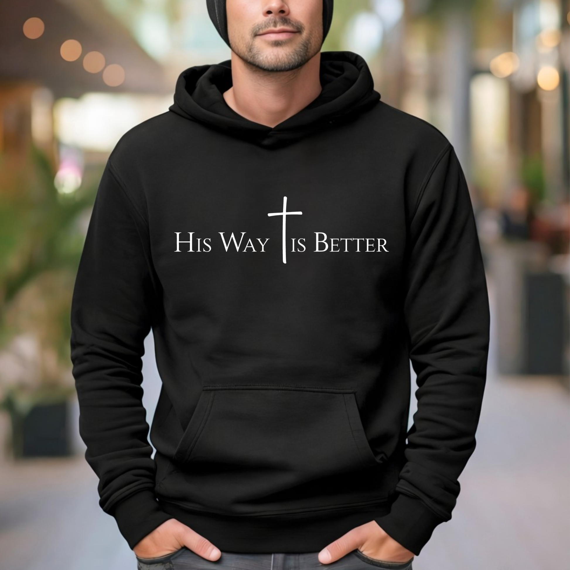Person wearing a black hoodie with 'His Way Is Better' text and cross design.