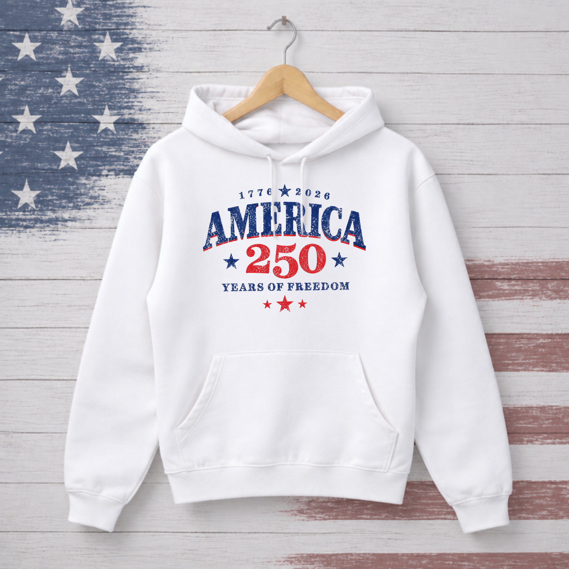 White hoodie with 'America 250 Years of Freedom' text on a wooden background with American flag pattern