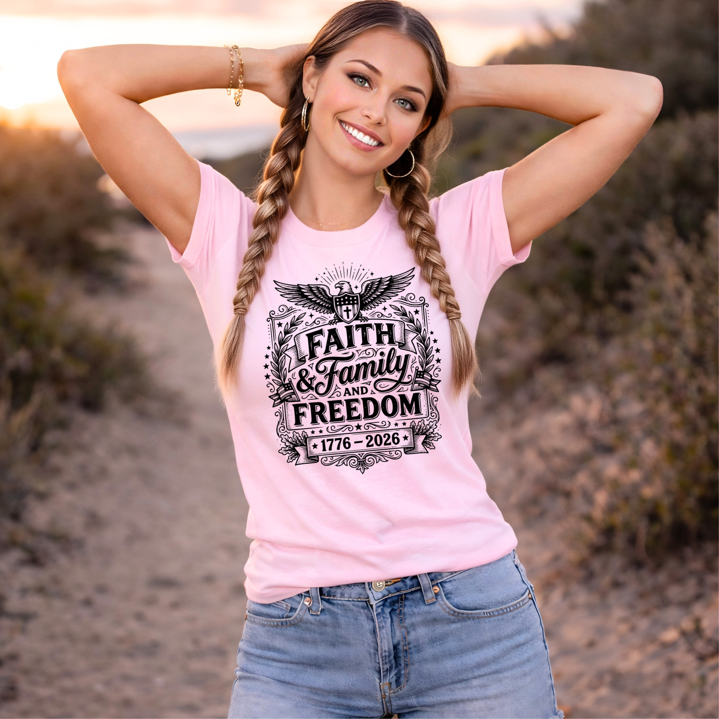Woman wearing a pink t-shirt with 'Faith & Family Freedom' design outdoors.