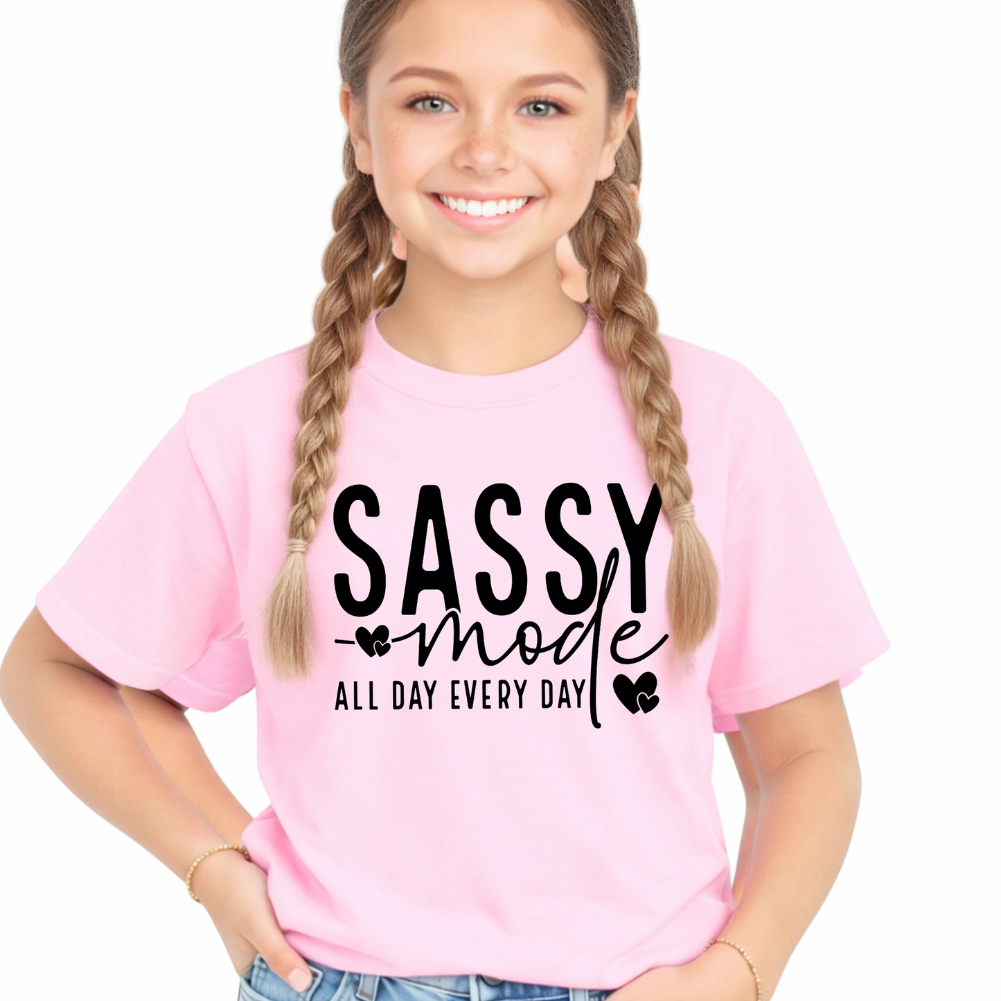 Young girl wearing a pink t-shirt with 'Sassy mode all day every day' text on a white background