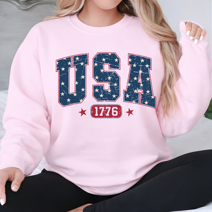 Woman wearing a pink sweatshirt with 'USA 1776' design