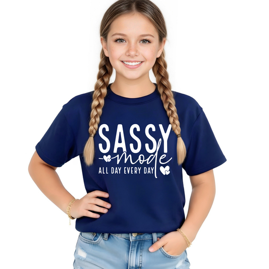 Young girl wearing a navy blue t-shirt with 'SASSY mode ALL DAY EVERY DAY' text on a white background