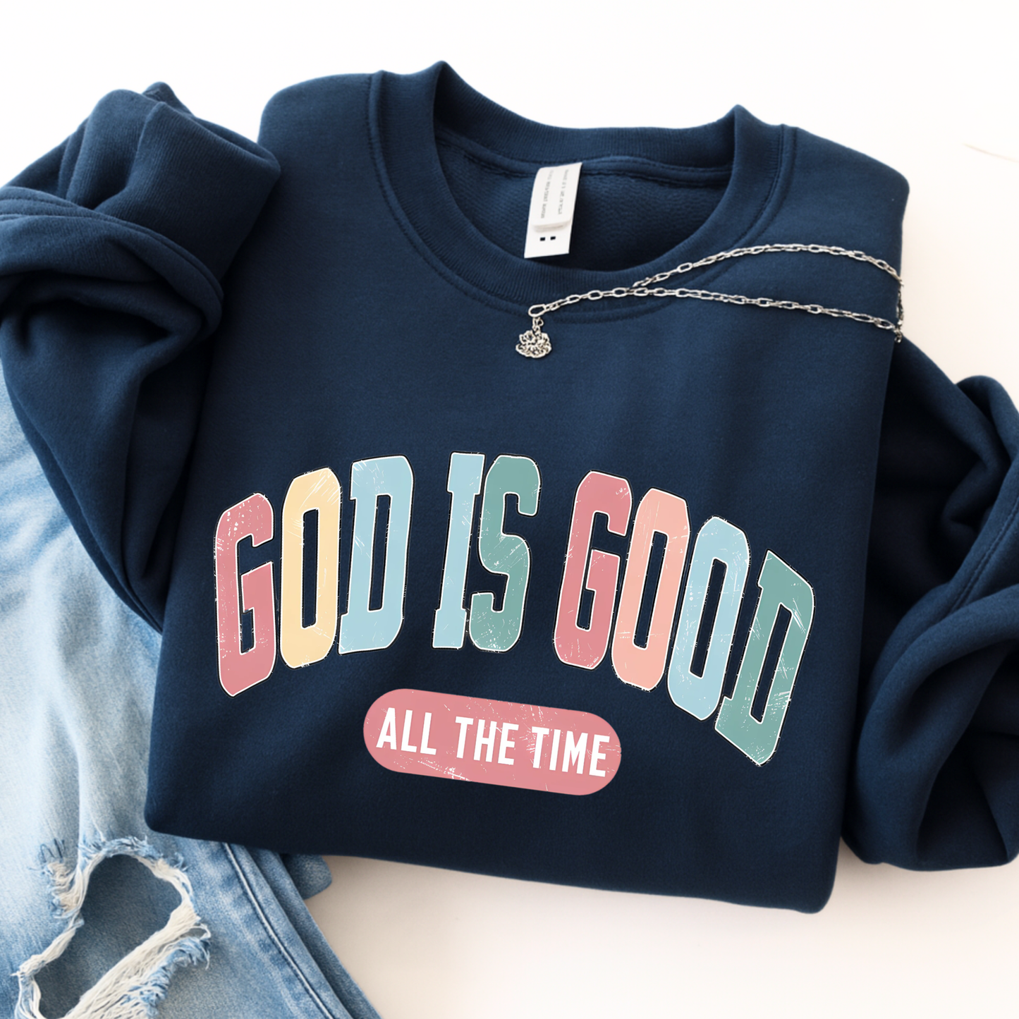 Navy blue sweatshirt with 'GOD IS GOOD ALL THE TIME' text on a light background