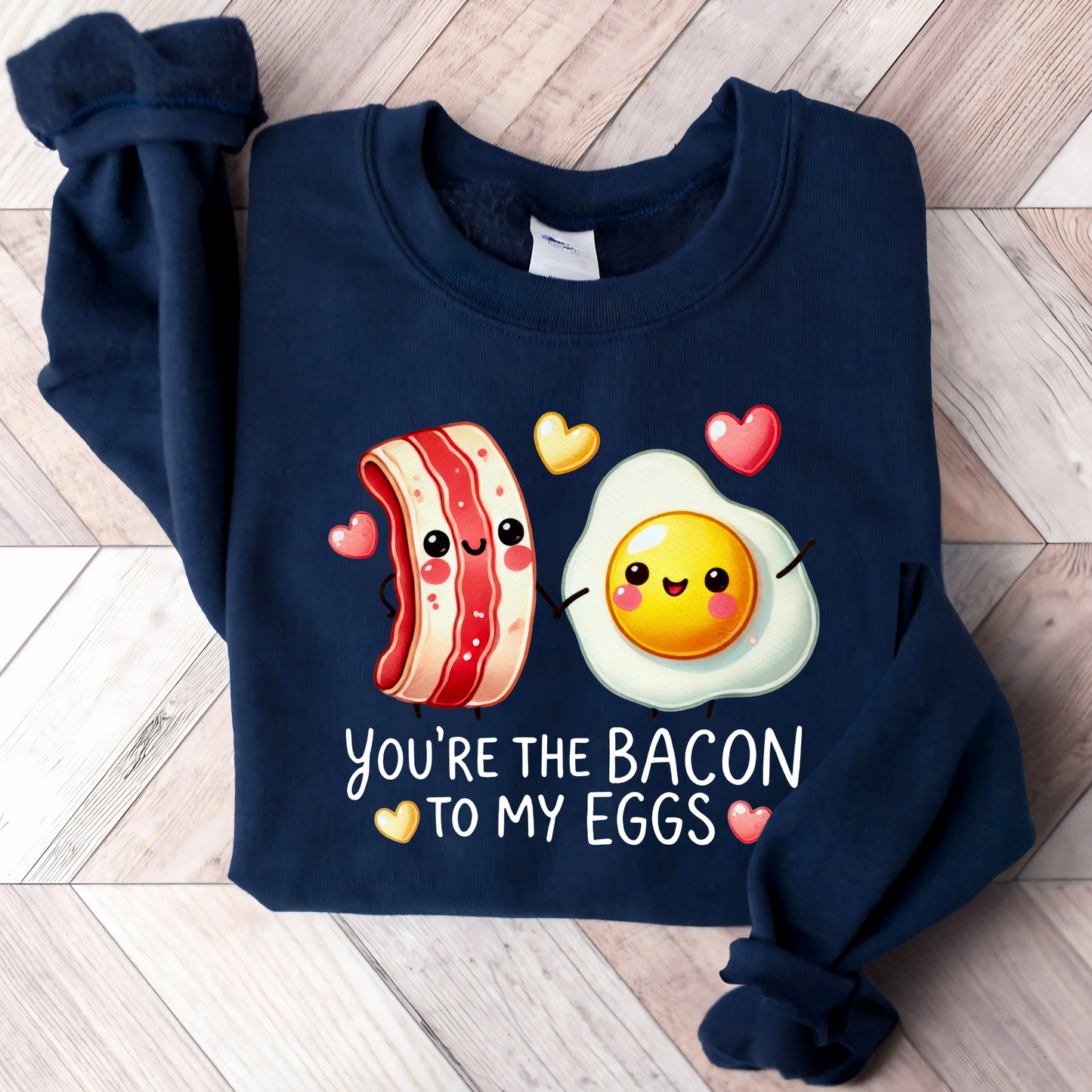 Navy folded sweatshirt with bacon and eggs graphic and romantic saying

