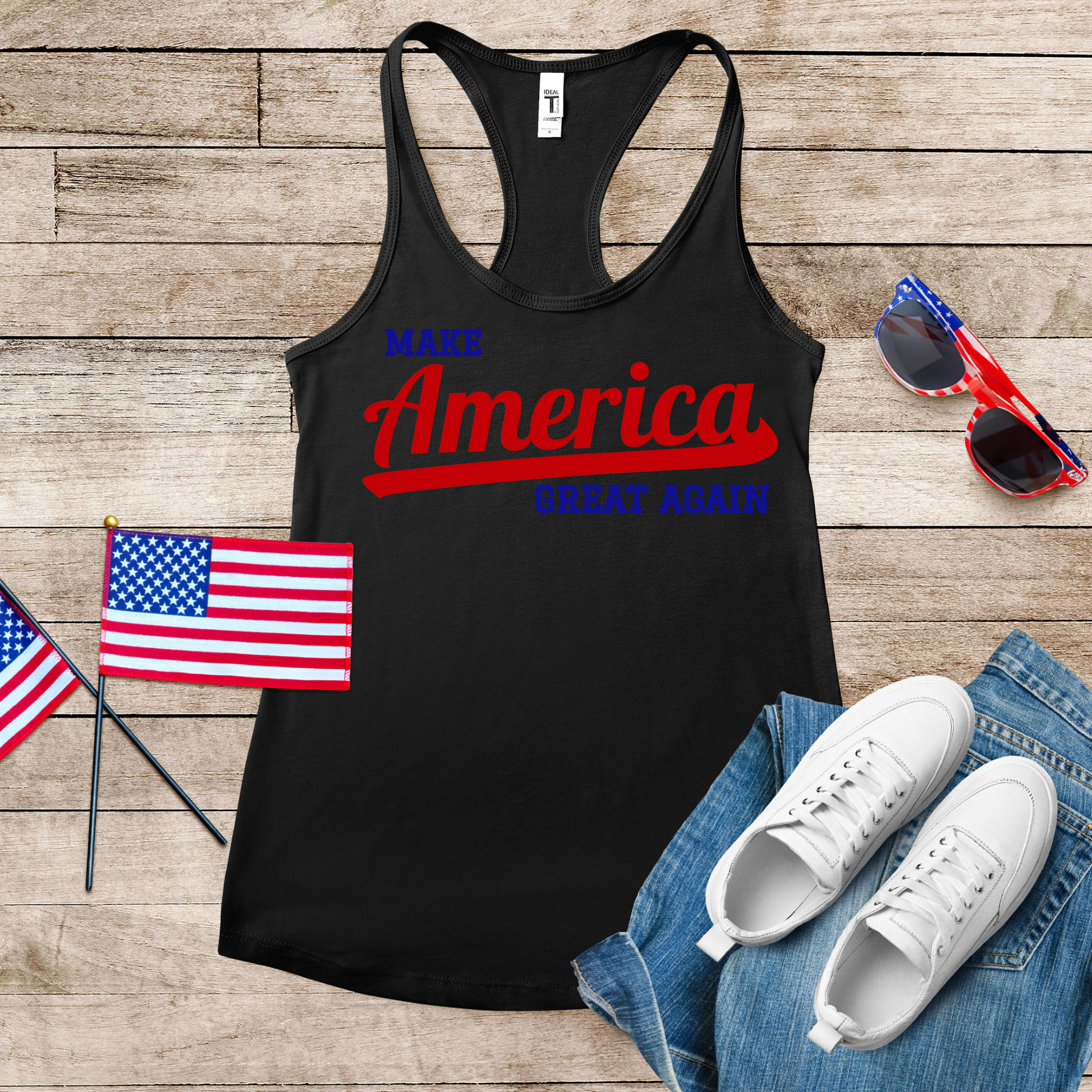 "Close-up flat lay of black MAGA tank top showing detailed vintage script design in red and blue with American Flag laying close