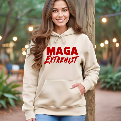 Woman wearing a beige hoodie with 'MAGA Extremist' text outdoors.