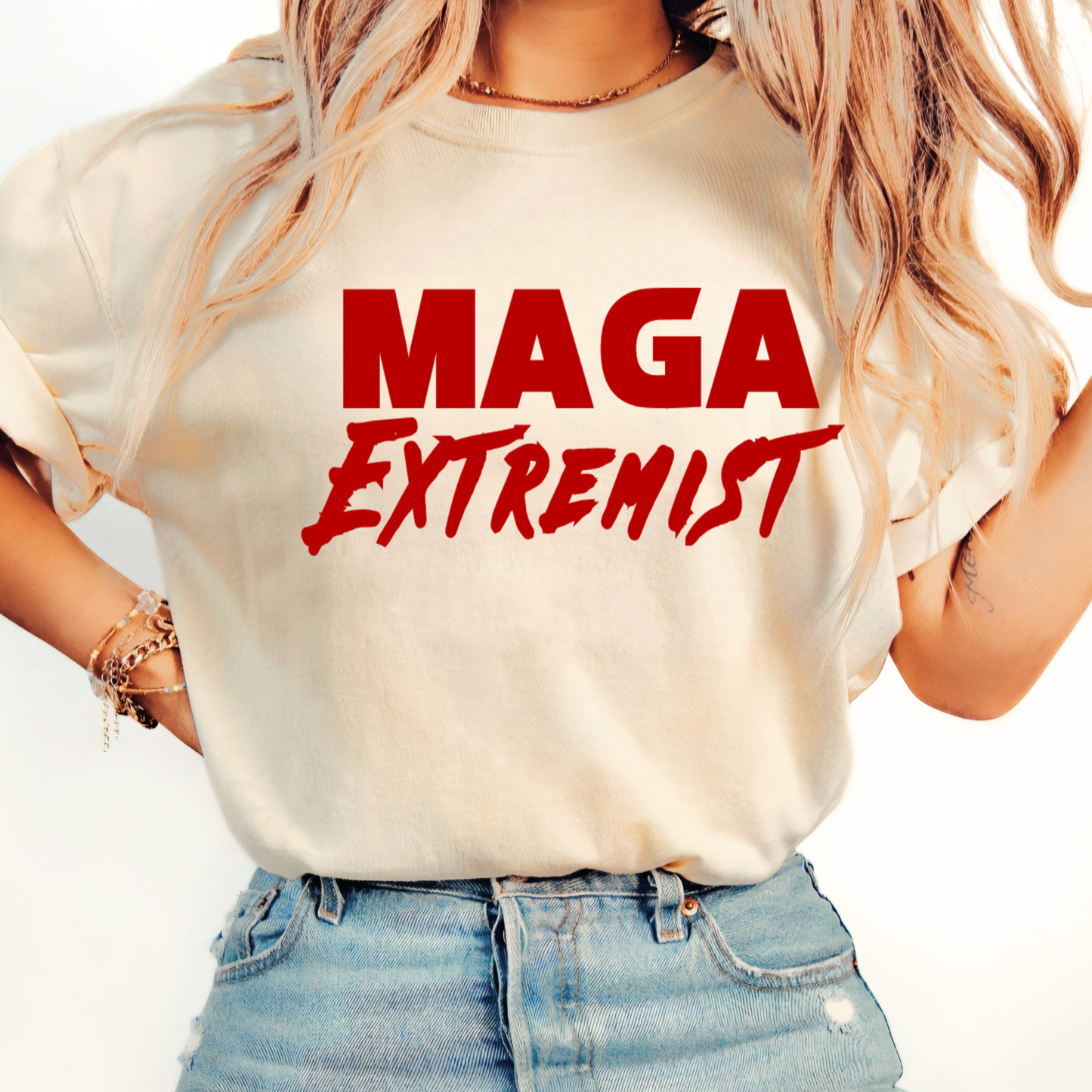 Person wearing a beige t-shirt with 'MAGA Extremist' in red text on a plain background