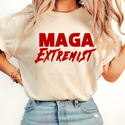 Person wearing a beige t-shirt with 'MAGA Extremist' in red text on a plain background