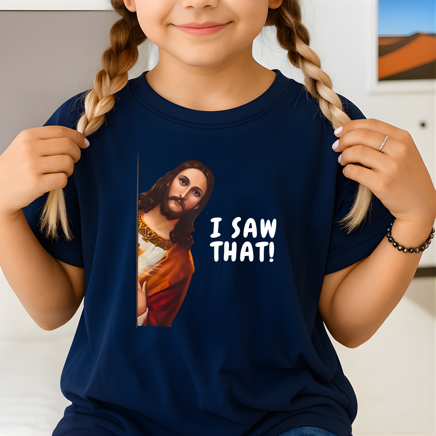 Child wearing a navy blue t-shirt with a graphic of a religious figure and text 'I SAW THAT!'
