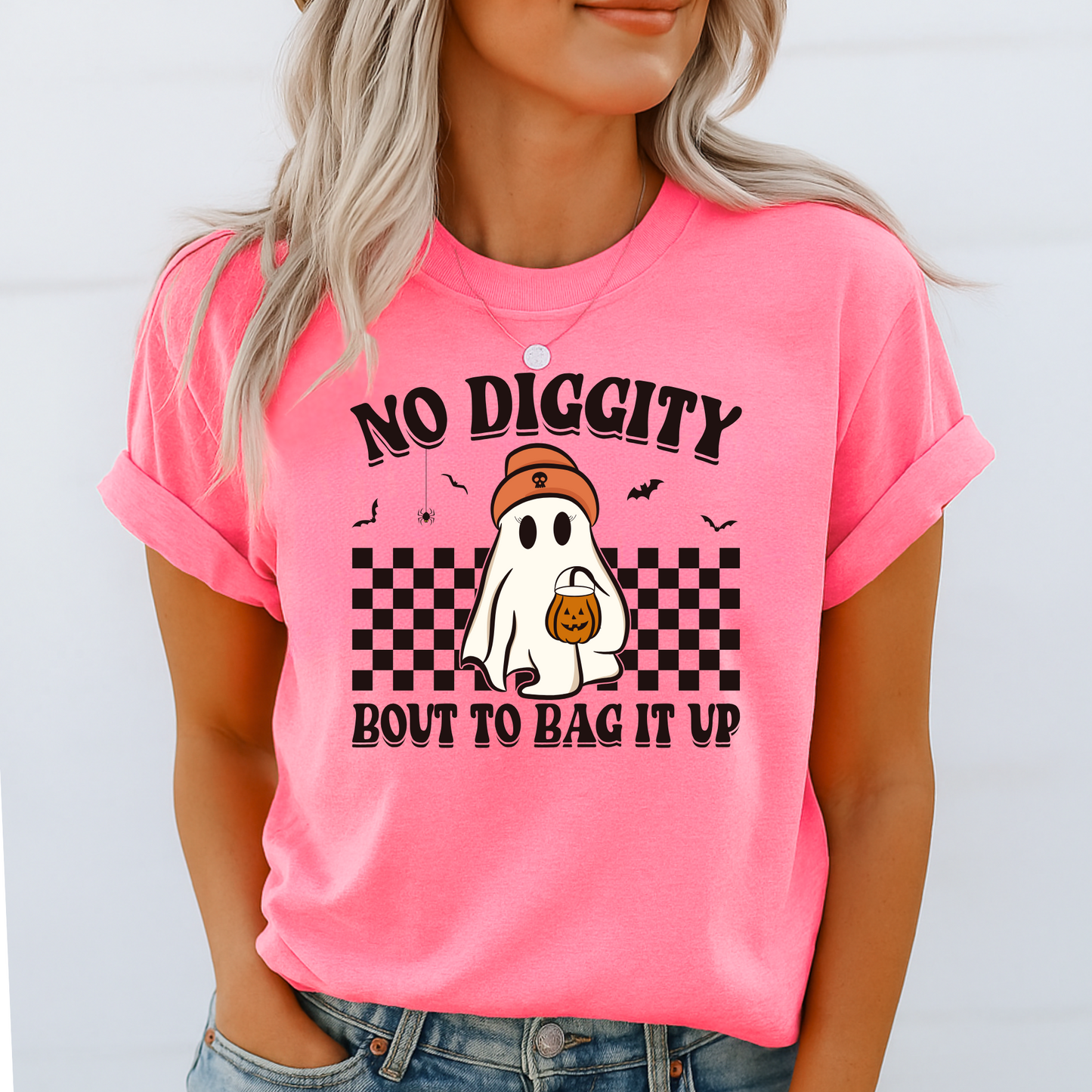 Person wearing a pink t-shirt with Halloween-themed graphic and text.
