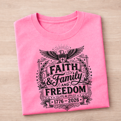 Folded pink Eagle 1776-2026 t-shirt with black graphic design on a wooden surface