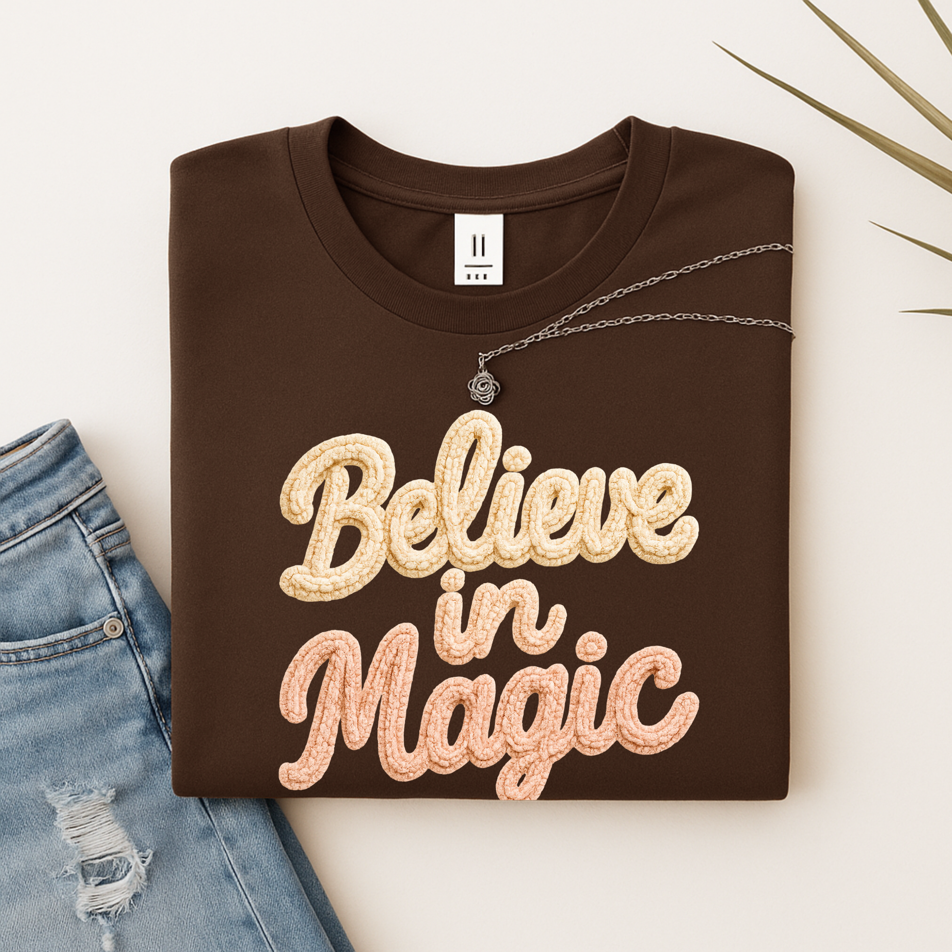 White sweatshirt with Believe in Magic faux crochet printed design, cozy winter crewneck Christmas shirt, holiday lifestyle photo, Black Friday find.