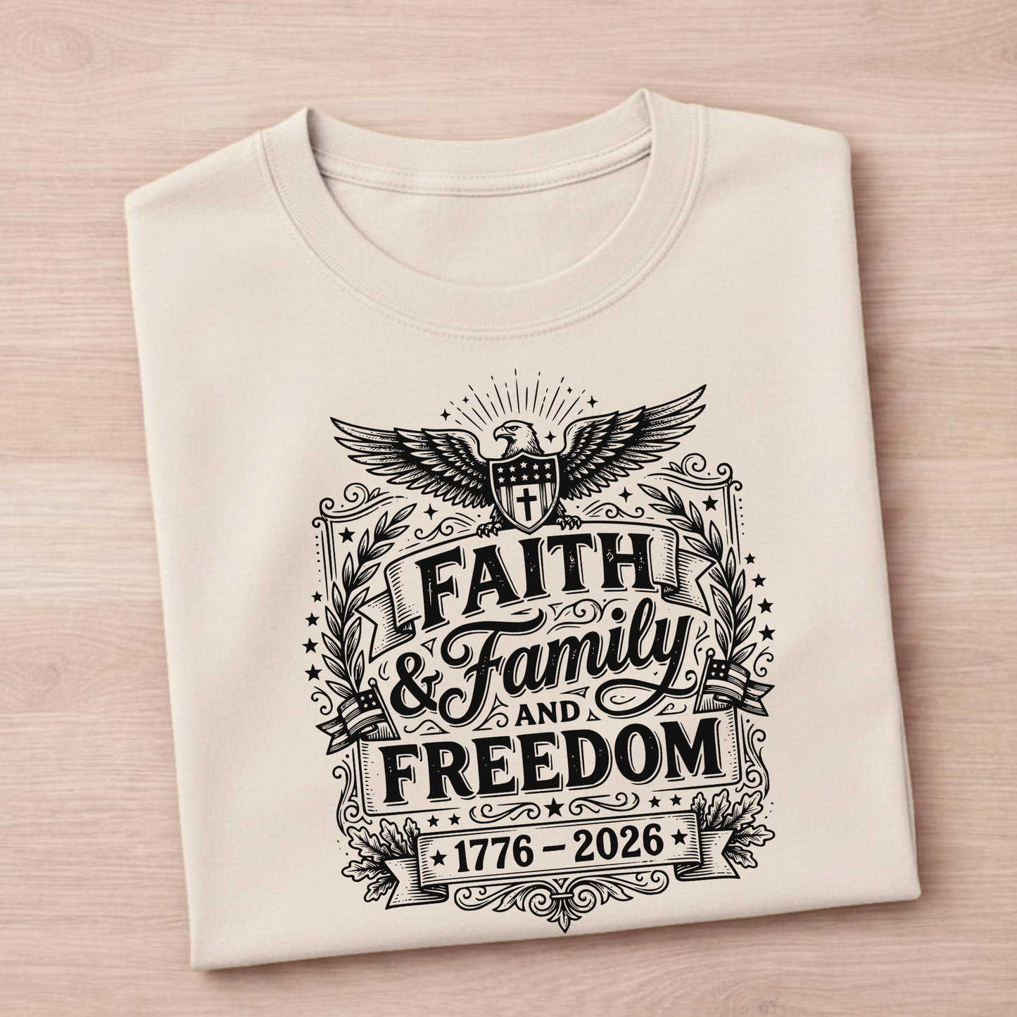 Folded sand colored patriotic t-shirt with black graphic design on a light pink background