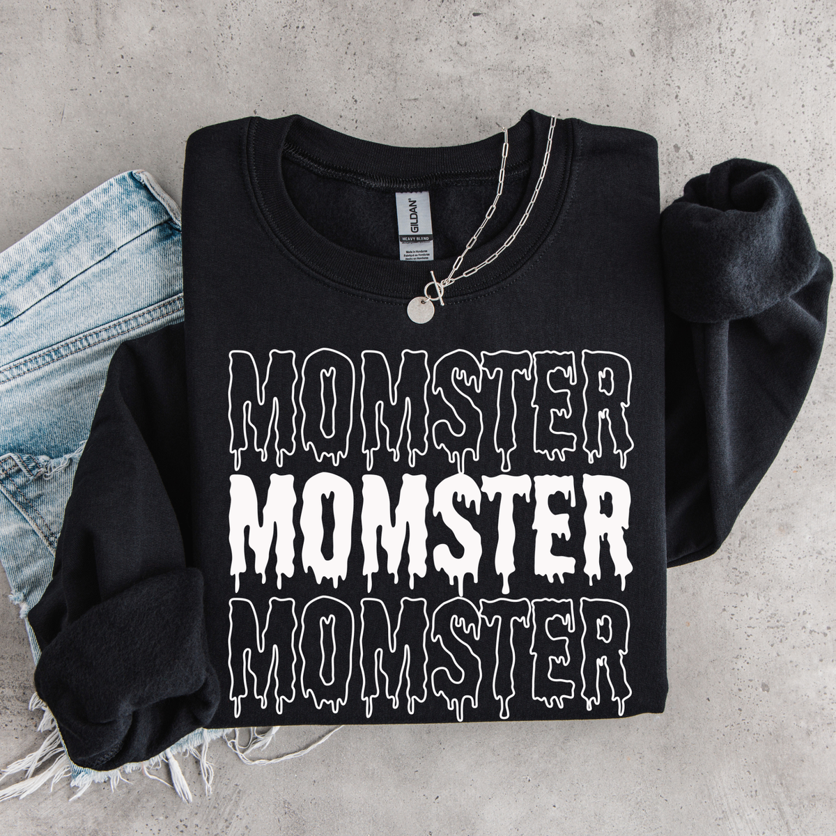 Woman modeling a MOMSTER Halloween graphic top with playful spooky-season details.