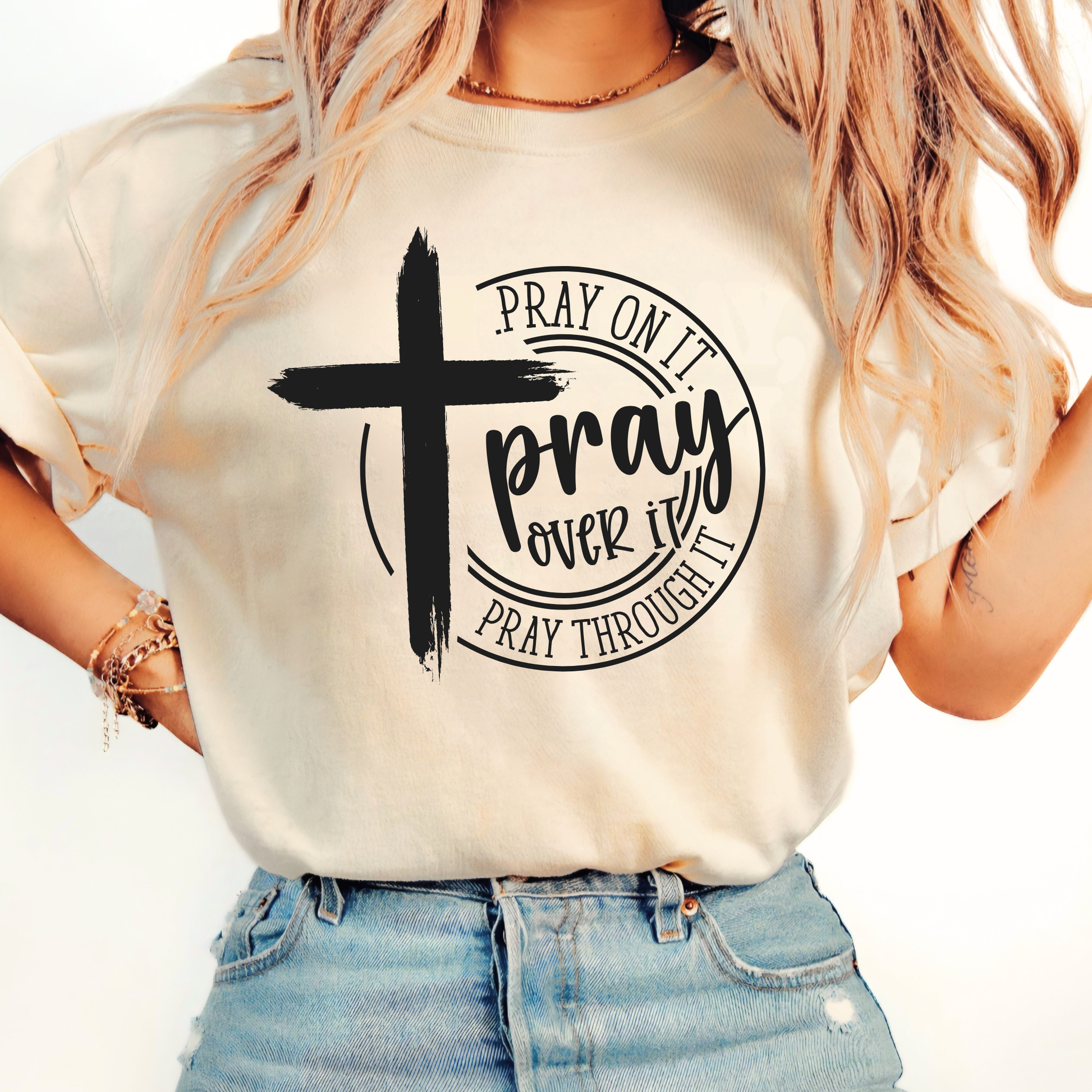 Person wearing a white t-shirt with a cross and text design.