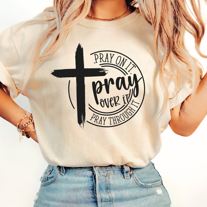 Person wearing a white t-shirt with a cross and text design.