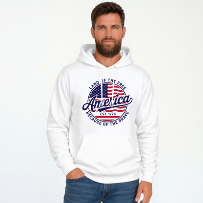 Male model wearing a white pullover hoodie with a red, white, and blue circular America graphic reading Land of the Free, Est. 1776, and Because of the Brave.