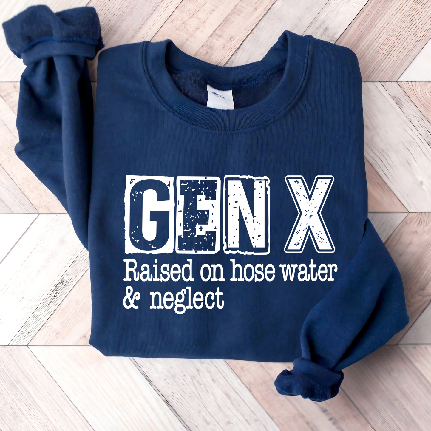 Navy blue sweatshirt with 'GEN X Raised on hose water & neglect' text on a wooden floor.