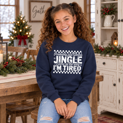 Girl wearing a navy youth sweatshirt with white Probably Just Gonna Jingle Some of the Way I'm Tired Christmas design in a festive dining room